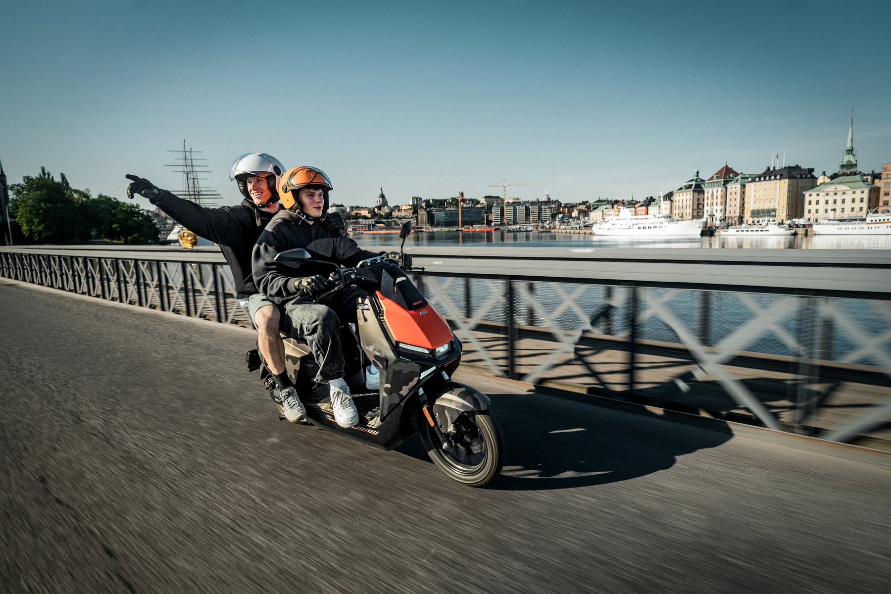 Oranger NIU FQiX bei einer Fahrt an der Uferpromenade