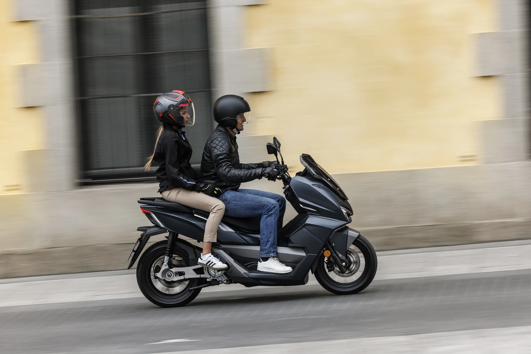 NERVA LIFT Elektroroller mit zwei Personen bei der Fahrt in der Stadt